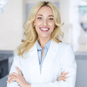 Smiling dentist in Kendall Park standing in a modern dental office.